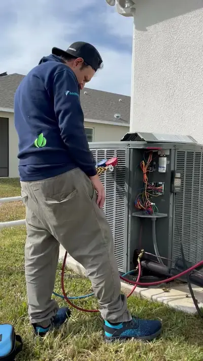 Synergie technician servicing an outdoor AC condenser unit