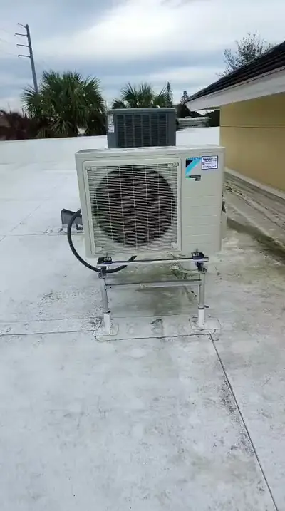 Wall-mounted mini-split condenser above a walkway