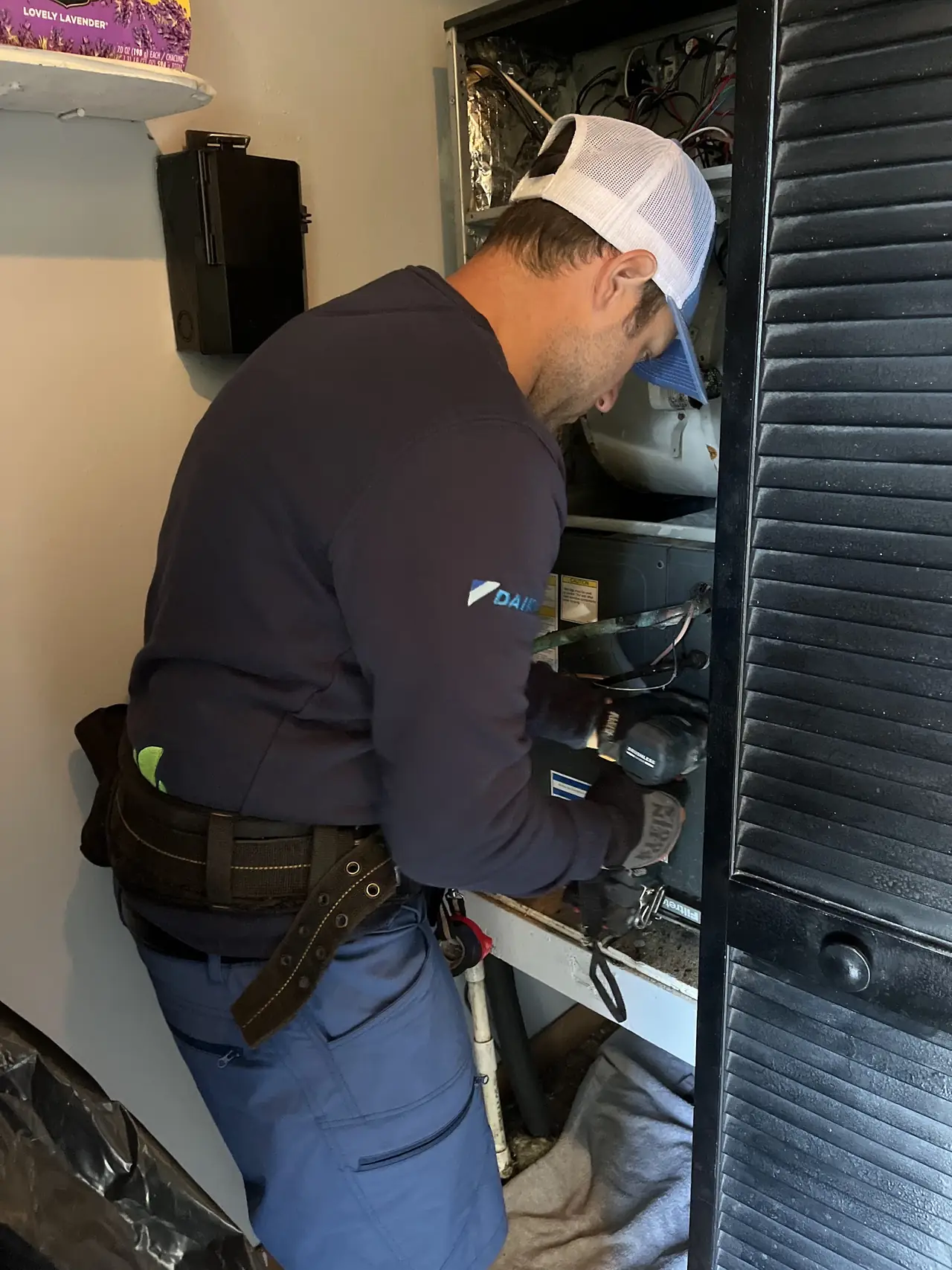 Technician working on an indoor air handler cabinet