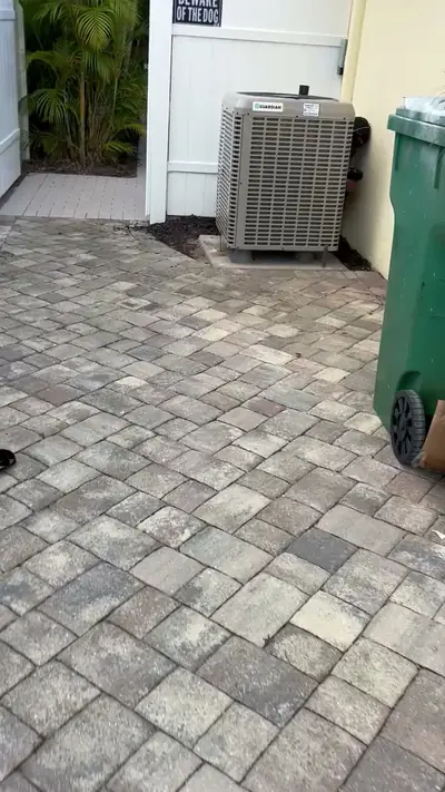 Condenser unit installed beside a paver patio
