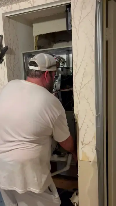Technician working inside an air handler closet