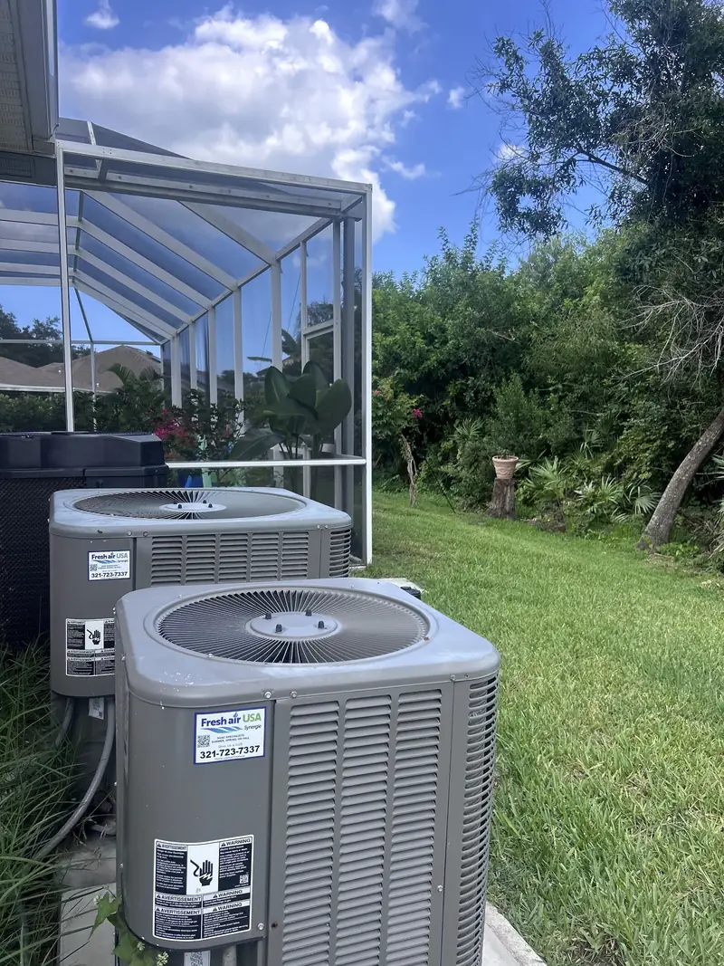 Two residential condensers on a lawn