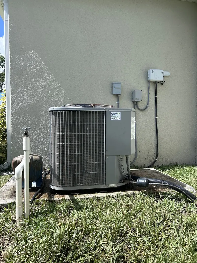 Condenser mounted against an exterior wall