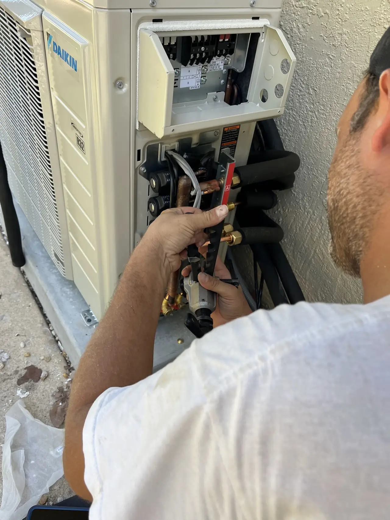 Technician wiring the control board of an outdoor unit