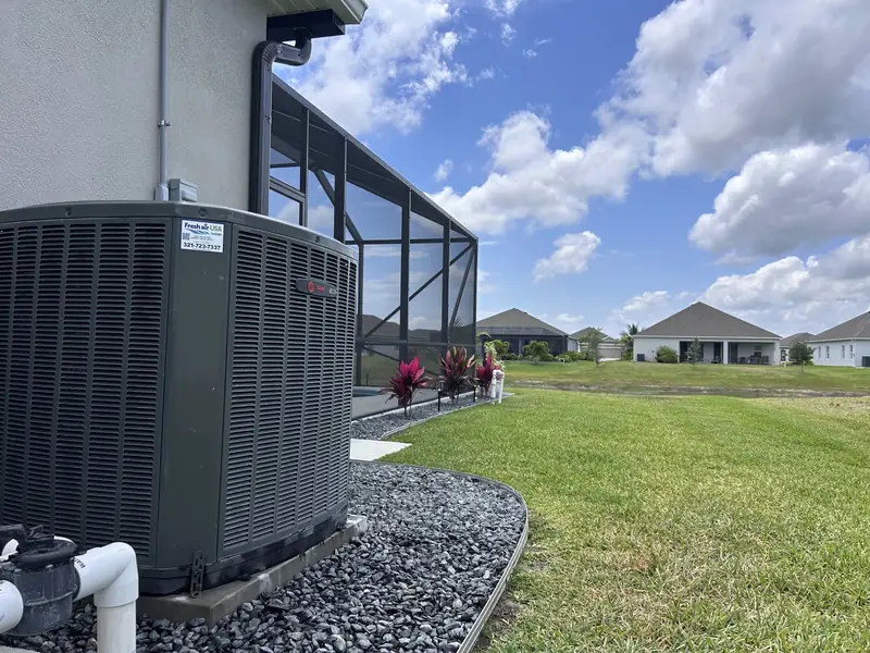 Condenser installed on a gravel bed beside a lanai