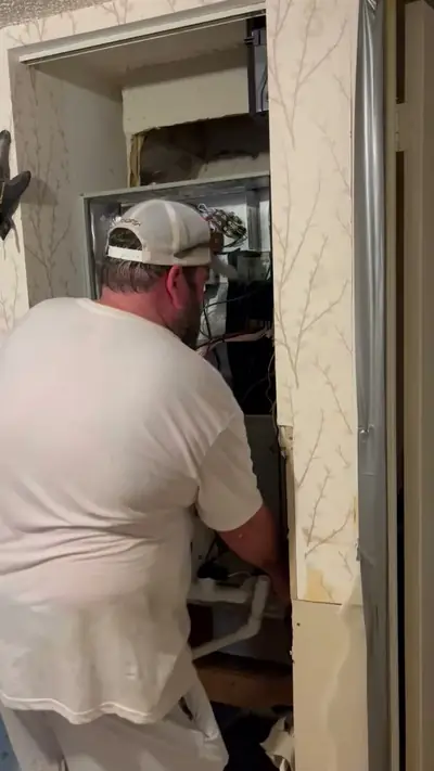 Technician fitting an air handler in a utility closet