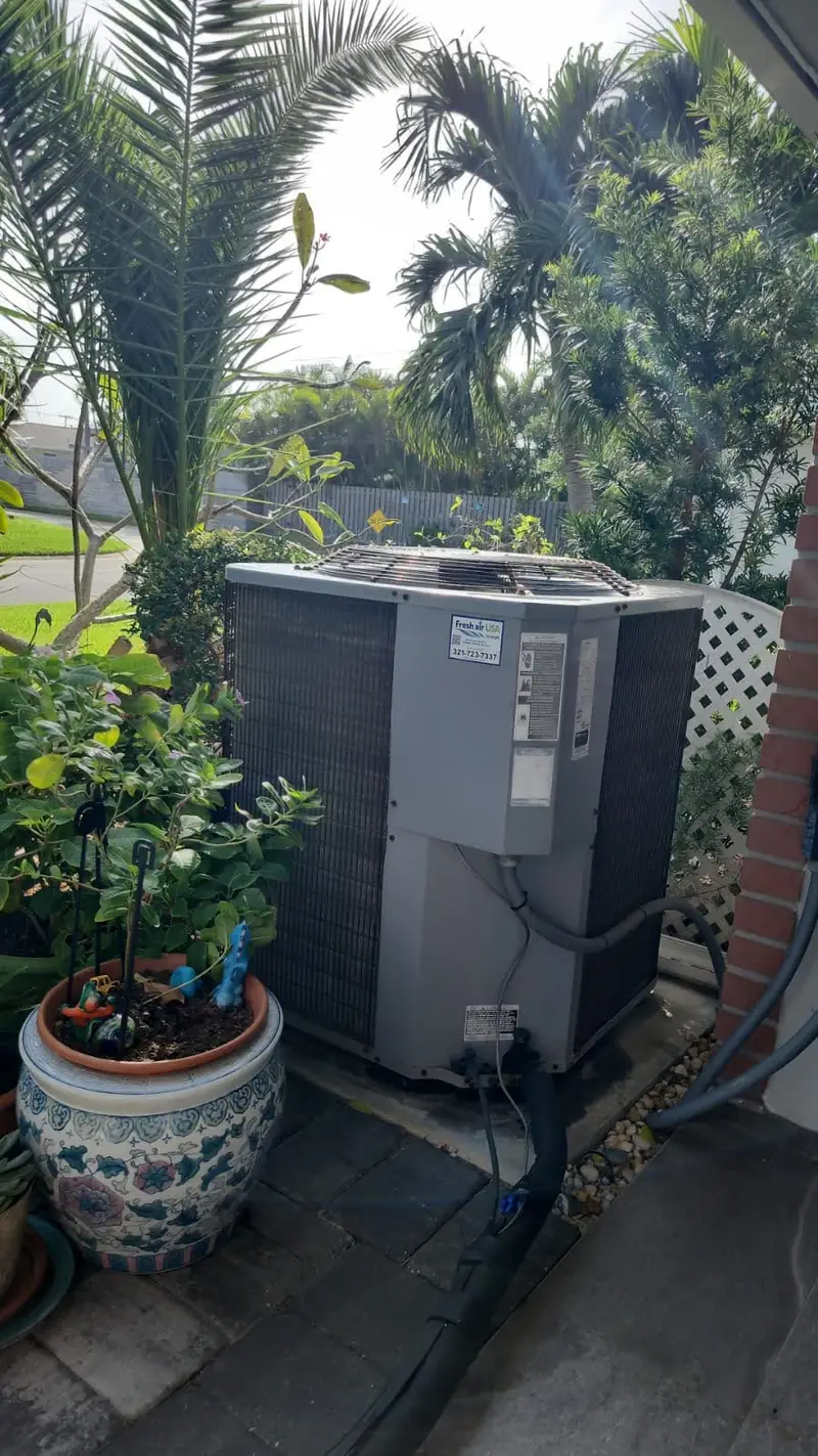 Condenser installed beside a potted garden