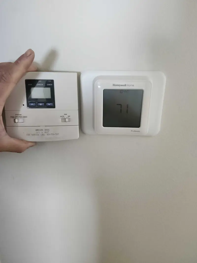 Hand adjusting a wall thermostat